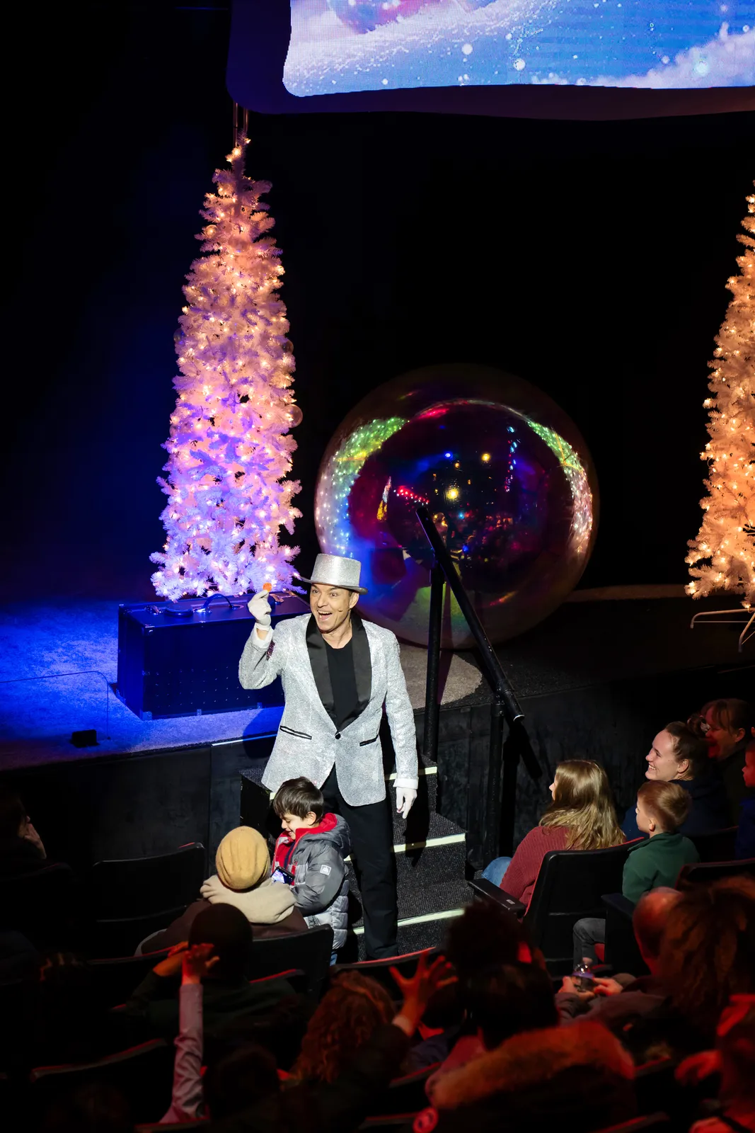 Holiday trees on stage as a bubble artist greets the audience